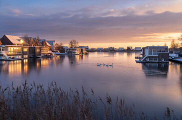 Fototapeta premium A colourful, winter sunrise in modern neighbourhood at the waterfront. Meerstad, the Netherlands.