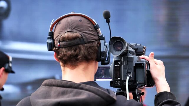 Cameraman filming broadcast event with professional video camera
