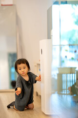 Curious Toddler Touching Air Purifier Indoors.