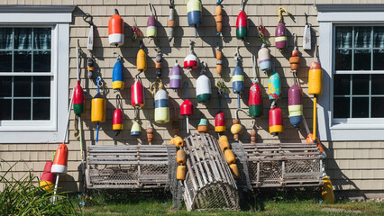 Hanging Lobster Buoys on Wooden Siding with Traps Below © jia