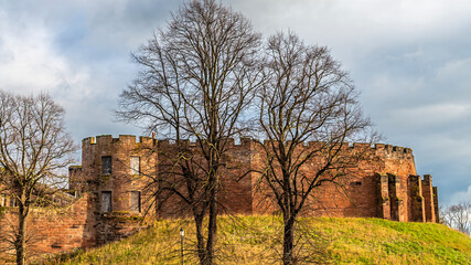 A view past trees towards the front of the castle in the city of Chester, Cheshire, UK