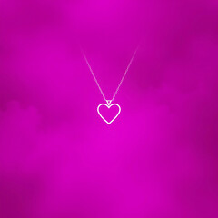 Delicate heart-shaped pendant necklace on a vibrant pink background. Romantic jewelry concept for Valentine&rsquo;s Day gifts and love symbolism.