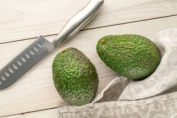 Ripe avocados on a wooden table, close-up, top view.