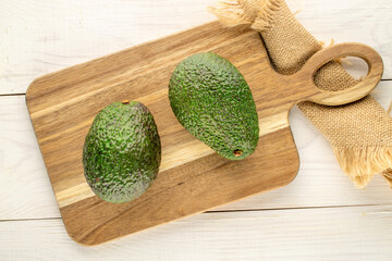 Ripe avocados on a wooden table, close-up, top view.