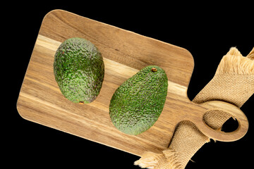 Ripe avocado isolated on black background, close-up, top view.