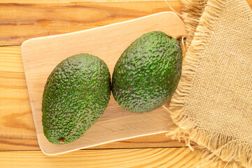 Ripe avocados on a wooden table, close-up, top view.