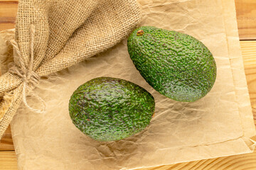 Ripe avocados on a wooden table, close-up, top view.