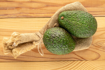 Ripe avocados on a wooden table, close-up, top view.