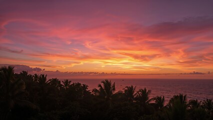 Sunset over the ocean with colorful sky and palm trees in the foreground. Evening scenery, nature, and tropical landscape.