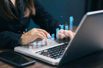 A professional using a laptop with rising digital charts and analytics, representing business growth, financial performance, data analysis, investment strategy, and modern corporate success concepts.