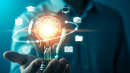 Businessman holding glowing lightbulb with education icons, symbolizing innovative ideas and learning