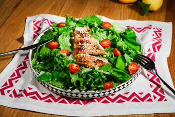 grilled chicken salad with green lettuce, grilled meat, green peas, tomatoes, lemons, fresh natural healthy mediterranean styled meal