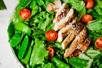healthy chicken salad with lettuce, green peas, cherry tomatoes, olive oil dressing