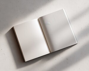 Blank open notebook mockup rests upon a textured light surface receiving dramatic diagonal sunlight shadows perfect for editorial design presentation and branding