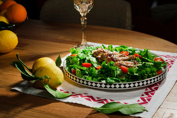 mediterranean styled salad with green lettuce leaves, peas, grilled chicken meat, cherry tomatoes, dressed with olive oil, served for one