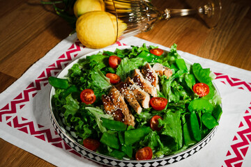 mediterranean styled salad with green lettuce leaves, peas, grilled chicken meat, cherry tomatoes, dressed with olive oil, served for one