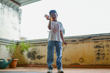 Boy playing with a toy on a balcony in the afternoon