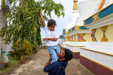 Father lifts daughter in temple courtyard