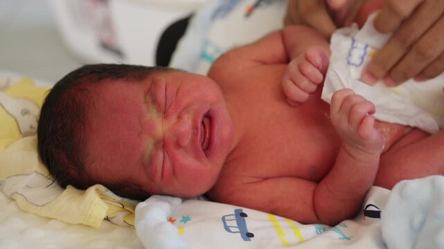 Newborn baby crying during a diaper change, captured in a realistic parenting moment. Shows infant care, emotion, and daily baby routine.