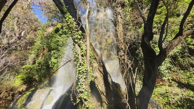 Close-up view of the water from the Fuentetoba waterfall flowing gracefully over the intricate textures of the moss-covered rocks, showcasing the raw beauty of the Golmayo River in Soria, Spain.