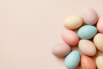 Colorful pastel Easter eggs on pastel beige background, soft spring holiday concept with copy space, colorful painted eggs, festive decoration Banner