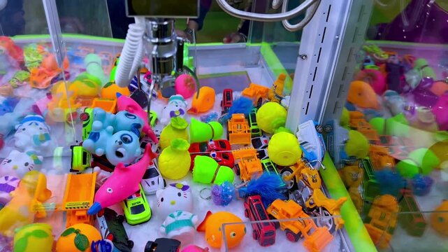 Double Claw Machine Picking Up Colorful Toys in Indoor Playground Arcade