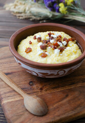 Traditional Banosh with cheese and bacon in rustic ceramic bowl
