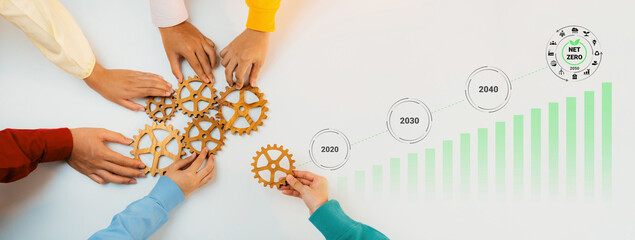 Obraz premium Hands unite to arrange gears, representing teamwork and strategic planning for future growth and sustainability in a collaborative workspace environment. Gantry
