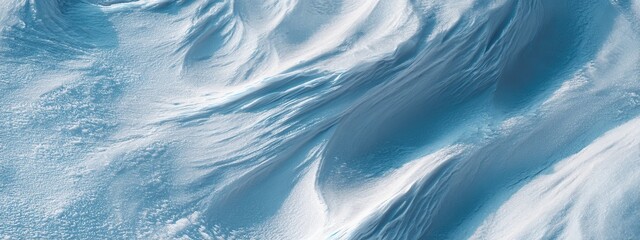 Pale Blue Patterns on Wind-Swept Surface Covered in Winter Snow with Textured Undulations and Gentle Curves