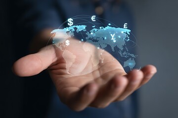 Hand holding glowing world map with major currency icons for international investment and banking