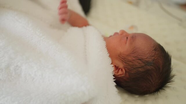 Newborn baby lying sideways after a bath, wrapped in a towel with focus on soft skin and peaceful facial expression. Ideal for hygiene, skincare, and baby care content.