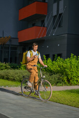 Bike courier delivering food on a bicycle in an urban environment, checking a mobile phone for directions, representing the gig economy and modern delivery service