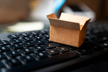 A small, open cardboard box is placed on a black keyboard, symbolizing ideas, creativity, and packaging. This scene is relevant for discussions on logistics, e-commerce, and workspace.