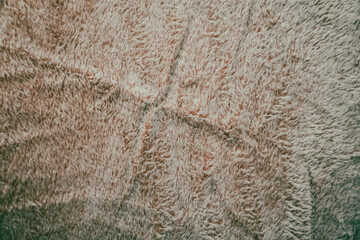 Soft, fluffy blanket texture in light beige tones, ideal for home decor or cozy settings, showcasing prominent smoothing patterns. Perfect for product presentations.