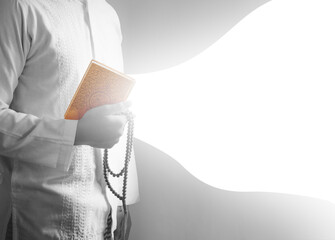 A conceptual image of a man in white clothing holding a Quran and prayer beads, featuring a large white graphic swoosh for text overlay and advertising design