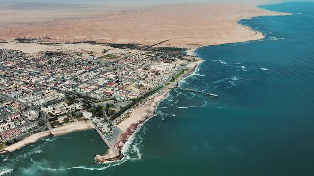 Stunning aerial drone video of Walvis Bay, Namibia, where vast desert dunes meet the Atlantic Ocean.