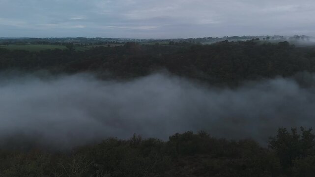 Aerial of hills and forest countryside in the fog