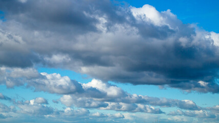 Blue sky with fluffy clouds lined up in a row