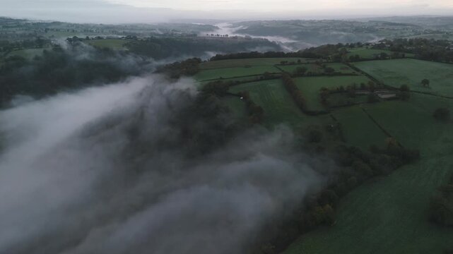Aerial of hills and forest countryside in the fog