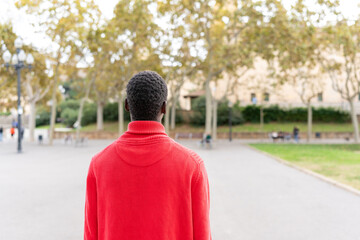Young African man enjoying outdoor travel, exploring a city park destination