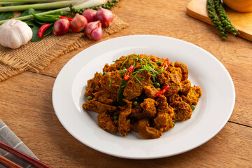 Stir Fried Beef with Yellow Curry Paste.Thai Southern Style Spicy sliced beef meat in white plate.(Kua-Kling)