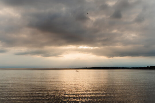 Dramatic summer evening view over the sea with a lone kayak and mainland horizon, Swedish West Coast