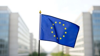 European union flag waving in front of blurred modern buildings in brussels