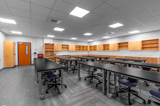Example of a new empty nondescript US High School science classroom with desks, chairs, and white board. Classroom could be in almost any US High School. Nobody included in image.