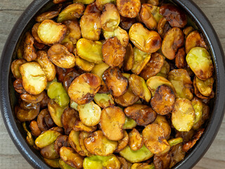 Top view of a bowl with roasted broad beans. Healthy vegan snack.