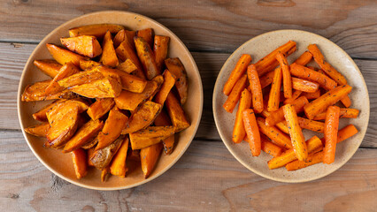 Root vegetables baked with honey and thyme: sweet potatoes on one plate, and carrots on another.