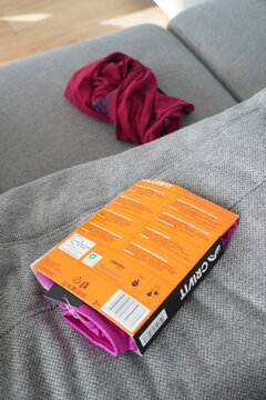 New pink sports bra in packaging with a red t-shirt on a sofa