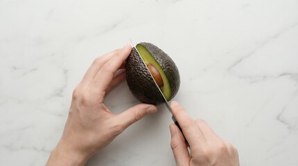 Hands Cutting Fresh Ripe Hass Avocado with Knife on White Marble Surface Top View