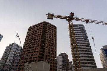 Bottom view of tower crane and skyscrapers under development