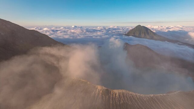 Drone hyperlapse aerial view flying orbit around mountain Kawah Ijen volcano crater during sunrise, Java, Indonesia 
